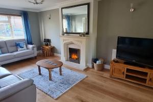 a living room with a fireplace and a television at Windsor property near Legoland with free parking in Windsor
