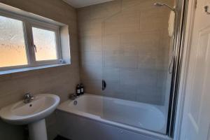 a bathroom with a tub and a sink and a shower at Windsor property near Legoland with free parking in Windsor +28 photos