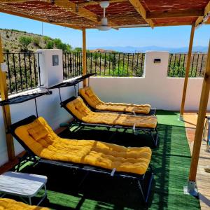 three empty chairs on a balcony with a roof at Casa Naturista Con Vistas in Oria