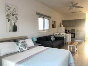 a bedroom with a bed and a living room at White House studio with sea view and parking in Polis Chrysochous