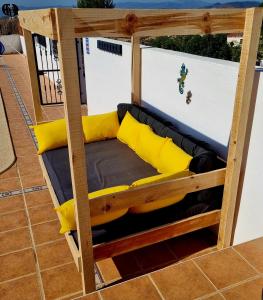 a wooden bunk bed with yellow pillows on a patio at Casa Naturista Con Vistas in Oria +71 photos