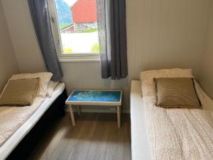 una piccola stanza con due letti e una finestra di Tunold Gård - Olahuset a Oppstryn