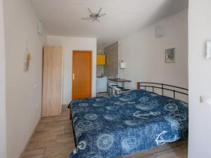 a bedroom with a blue bed and a kitchen at Apartmani Maria - Studio 2 in Vantačići