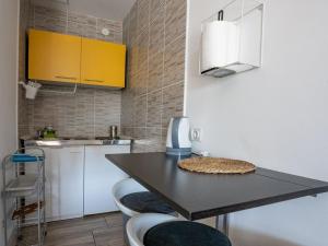 a kitchen with a table with two stools and a counter at Apartmani Maria - Studio 2 in Vantačići