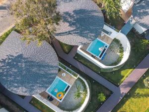 an overhead view of three large circular swimming pools at SaroRach pool villa resort Kohlarn in Ko Larn
