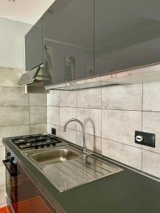 a kitchen with a sink and a stove at Lupin House in SantʼAngelo Romano +22 photos