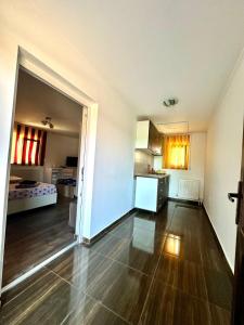 an empty room with a kitchen and a living room at Pensiunea Bianca in Corbu
