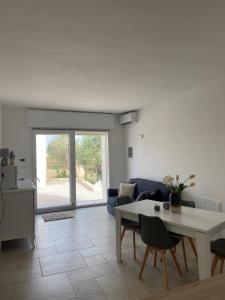 a living room with a table and a blue couch at Country House in Torre San Giovanni Ugento