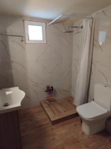 a bathroom with a toilet and a sink and a window at Michael House in Kavala +19 photos