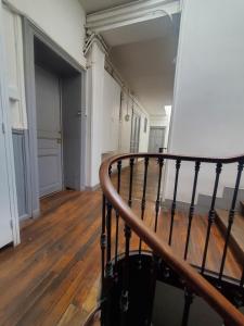 a staircase in an empty room with wood floors at Hypercentre Capitole T2 vaste et lumineux in Toulouse