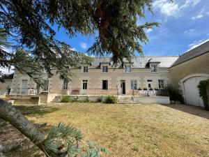 an exterior view of a large house with a yard at Aux Chambres des Dames in Chisseaux