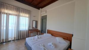 sypialnia z łóżkiem z umywalką i oknem w obiekcie Hercules Hills Sea View Villas w mieście Kos