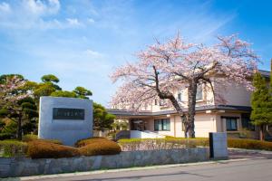 函館市にあるKKRhakodateの建物の前に花の咲いた木がある建物 +1枚の写真