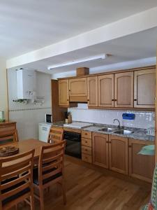 a kitchen with wooden cabinets and a wooden table with a sink at Dúplex de muntanya en zona verda a Escaló in Escaló