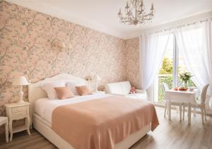 カンヌにあるCannes Imperial Croisette Palais Miramarのベッドと机と窓のある寝室