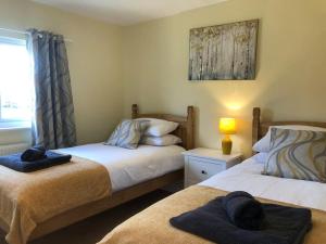 a bedroom with two beds with towels on them at Nightjar Lodge - Adults Only in Lackford