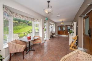 a dining room with a table and chairs and windows at Coach Hill House in Cork
