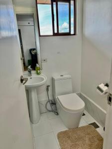 une salle de bains blanche avec toilettes et lavabo dans l'établissement cozy2ndhomeFRM, à Manille