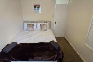 a bedroom with a large bed with pillows at Eastpark 5 bdrms Walk to O2 Apollo and City in Manchester