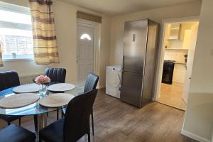 a dining room with a table and a refrigerator at Eastpark 5 bdrms Walk to O2 Apollo and City in Manchester