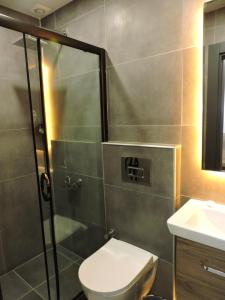 a bathroom with a shower and a toilet and a sink at Başar hotel in Erdemli