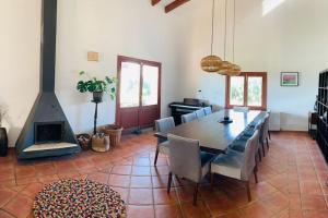 a dining room with a table and a fireplace at Stunning country villa with Panoramic mountain views in Biniali