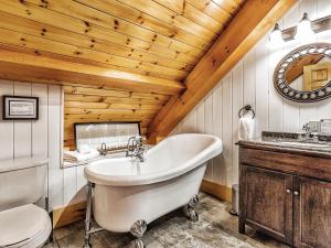 ein Badezimmer mit einer weißen Badewanne und einem WC in der Unterkunft Le Mont-Tremblant - Résidences Boutique in Lac-Superieur