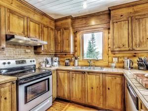 eine Küche mit Holzschränken und einer Spüle in der Unterkunft Le Mont-Tremblant - Résidences Boutique in Lac-Superieur
