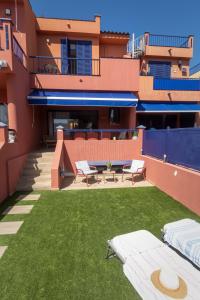a building with a yard with two beds on it at Marevento Meloneras in Meloneras