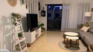 a living room with a couch and a tv at Marevento Meloneras in Meloneras +16 photos