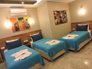 a room with two beds with towels on them at Başar hotel in Erdemli