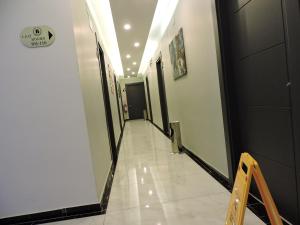 a corridor of a hallway with white tile floors and ceilings at Başar hotel in Erdemli