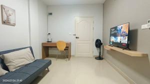 a living room with a couch and a flat screen tv at Fuengfa Room in Khlong Luang