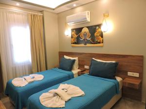 two beds in a hotel room with towels on them at Başar hotel in Erdemli
