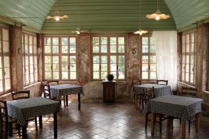 a dining room with tables and chairs and windows at Gorska Roža B&B in Log pod Mangartom