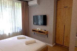 a bedroom with a bed and a tv on a wall at Greenwood in Borjomi