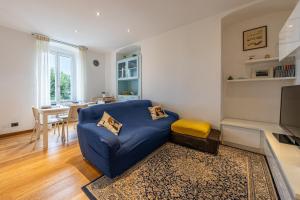een woonkamer met een blauwe bank en een tafel bij A CASA DEL BOSCHETTO Vista, Relax e Comfort in Camogli