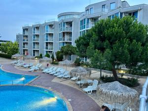 a resort with a pool and chairs and a building at Atlantis Resort & 4 swimming pools & Spa & Апартамент in Burgas City +34 photos