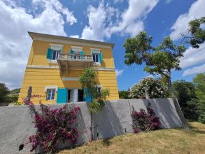 坎普码头Villa le Api的黄色房子,设有阳台和鲜花