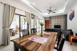 Un comedor con una mesa y un sofá. en MM Pool Villa, en Pattaya South