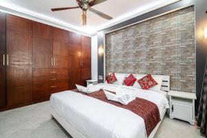 Un dormitorio con una cama blanca y una pared de ladrillo. en MM Pool Villa, en Pattaya South 23 fotos más