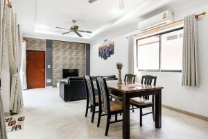 Un comedor y una sala de estar con mesa y sillas. en MM Pool Villa, en Pattaya South