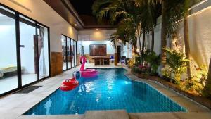 una piscina con un cisne rosa en una casa en MM Pool Villa, en Pattaya South