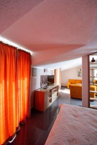 a bedroom with orange curtains and a couch at Villa SHU in Krimovice