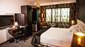 um quarto de hotel com uma cama e uma televisão em Coastlands Umhlanga Hotel and Convention Centre em Durban