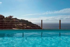 a swimming pool with a view of the ocean at Loleni House sub 25 Welcome in Costa Paradiso