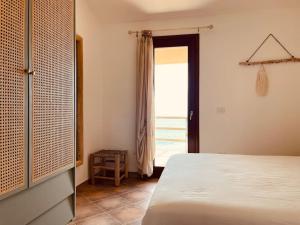 a bedroom with a bed and a door to a patio at Loleni House sub 25 Welcome in Costa Paradiso