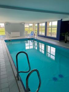 een groot zwembad met blauw water bij Vue Sur Green in Levernois