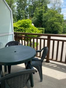 een blauwe tafel en stoelen op een balkon bij Vue Sur Green in Levernois