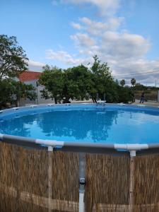 a large blue swimming pool with a wooden fence at Casa do Avô Ezequiel in Vendas Novas
